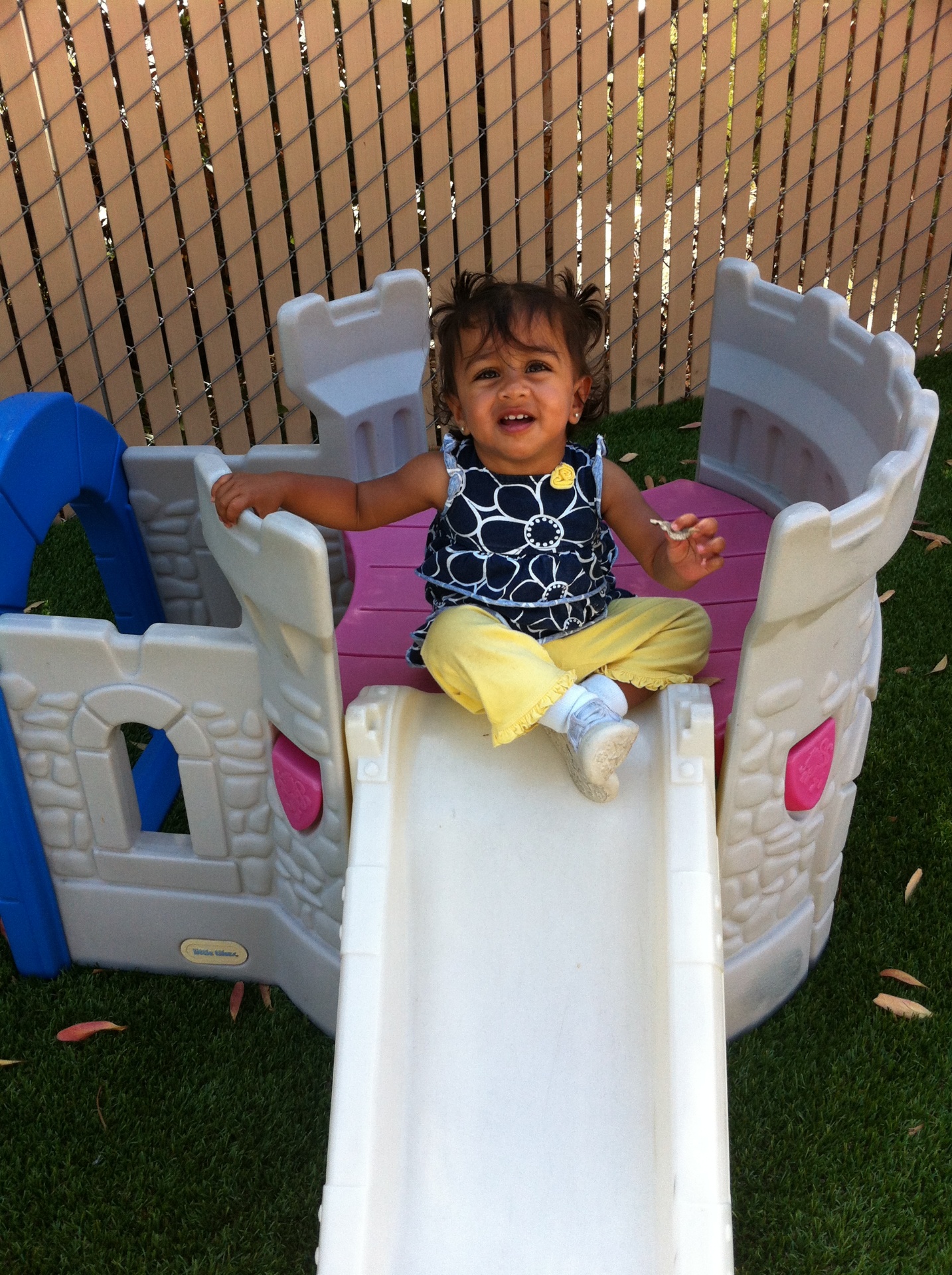 Happy toddler on a castle slide at Happy Minds Kids Academy